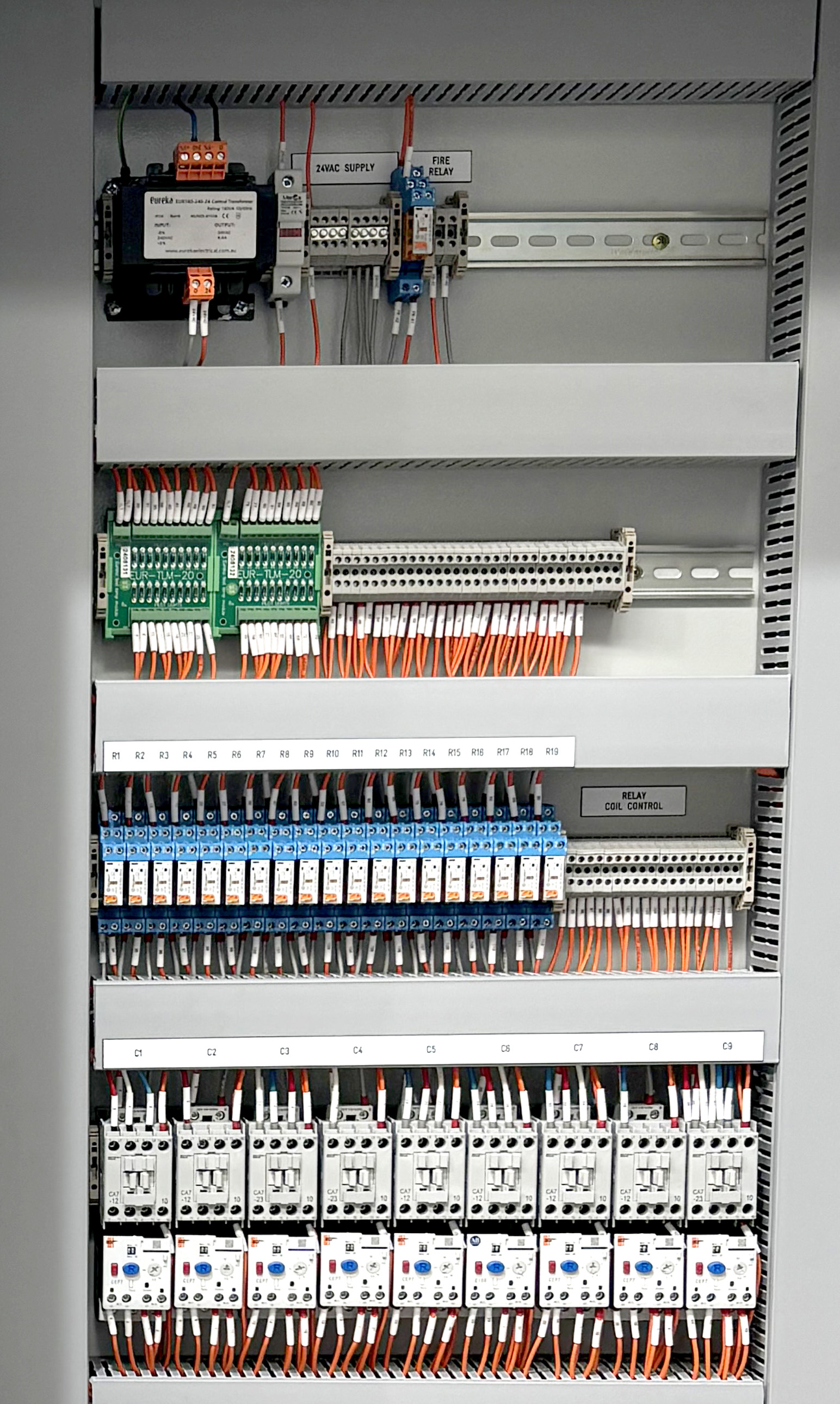 Industrial electrical board featuring multiple contactors and circuit breakers arranged in rows, with control wiring routed through terminal blocks for efficient power distribution