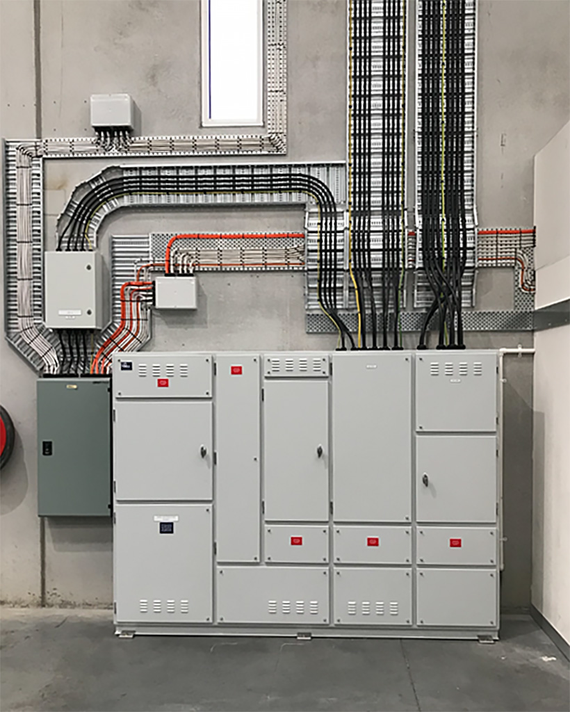 Electrical control room with several floor-standing switchboards managing power distribution for a large facility