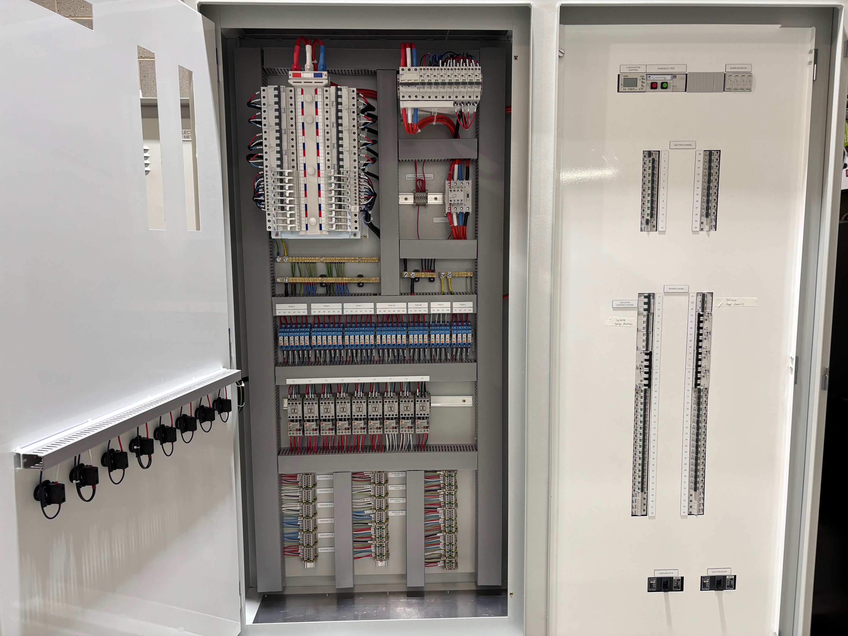 Weatherproof switchboard at a petrol station with integrated safety shut-off controls, emergency power disconnects, and secure wiring for fuel pump systems